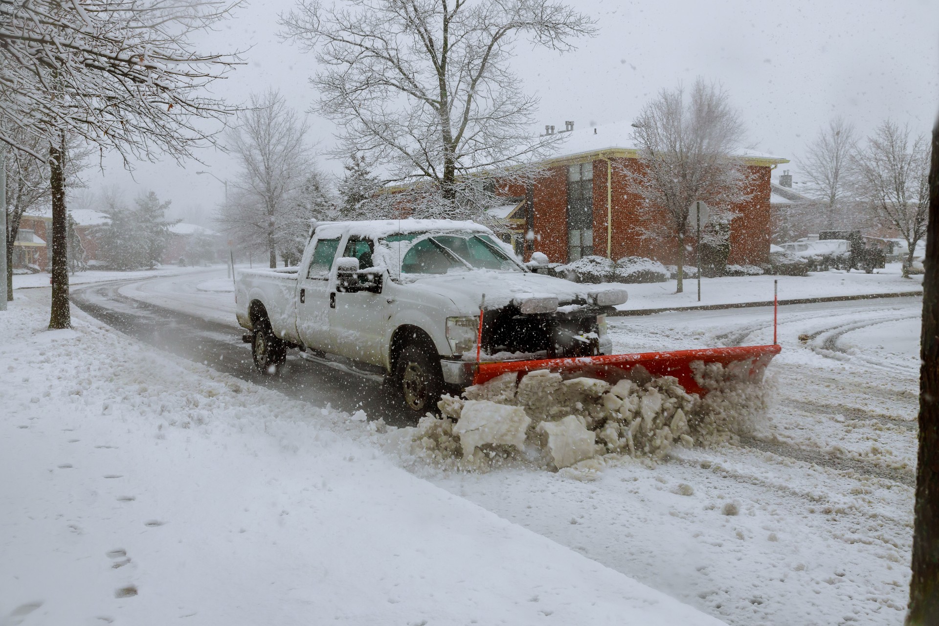 Snow plow removing snow from street.